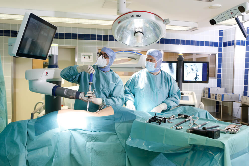 Während der Wirbelsäulenoperation schauen unsere Ärzte die in Echtzeit geleiferten Informationen auf dem Bildschirm an.